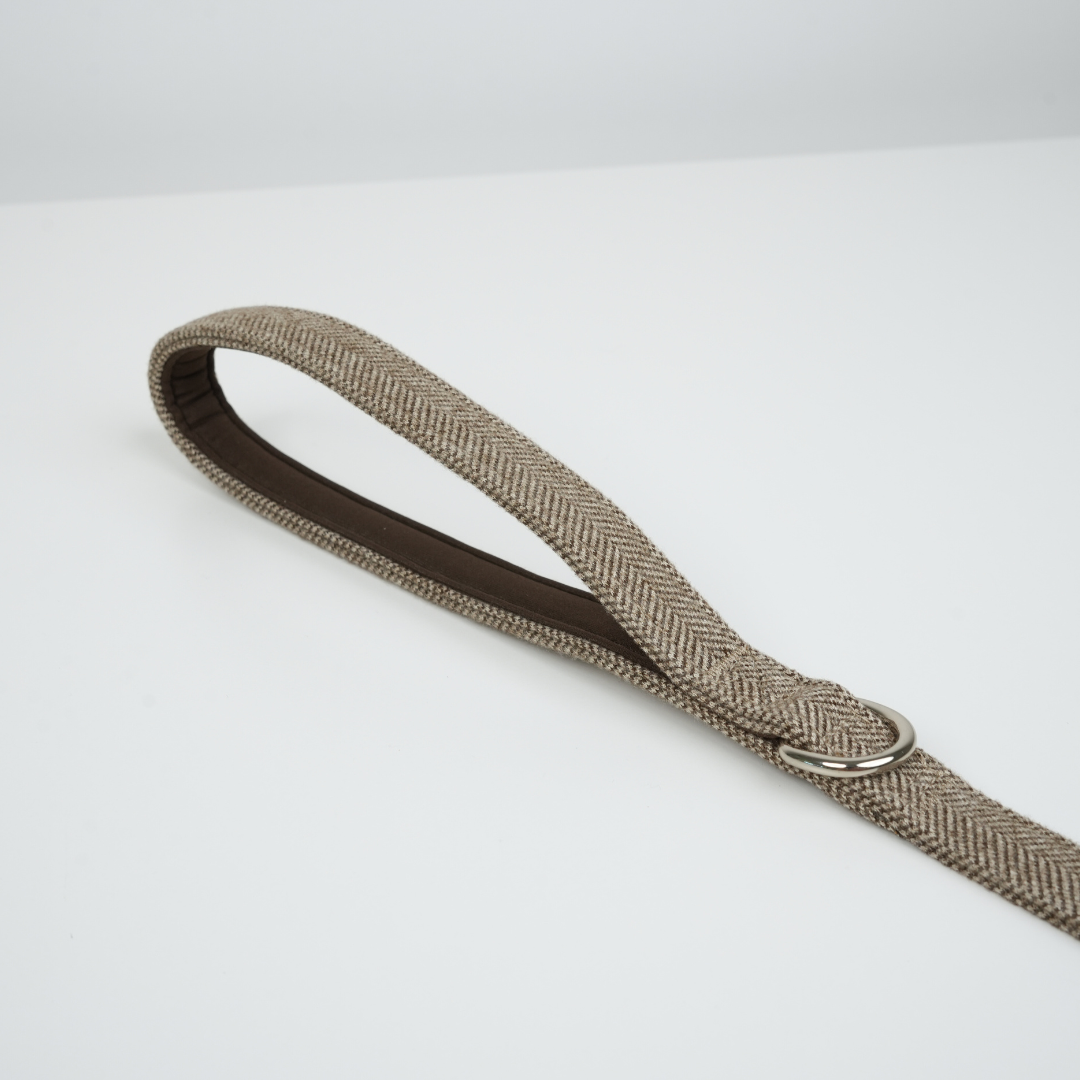 Beige woven belt with a silver buckle on a white background