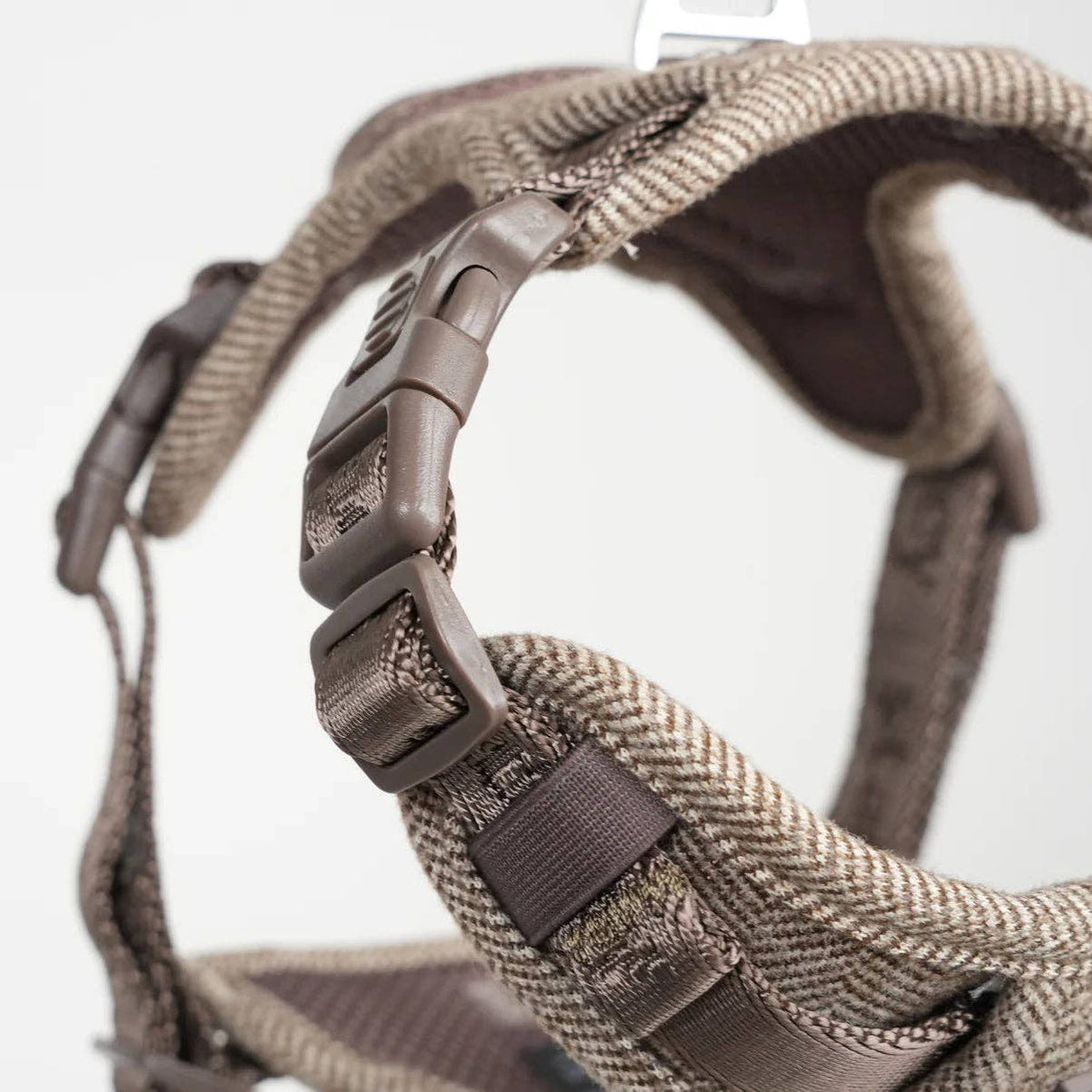 Close-up of a brown dog harness with a white background