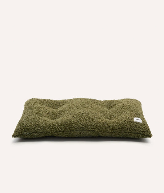 Green pet bed with a brand label on a white background