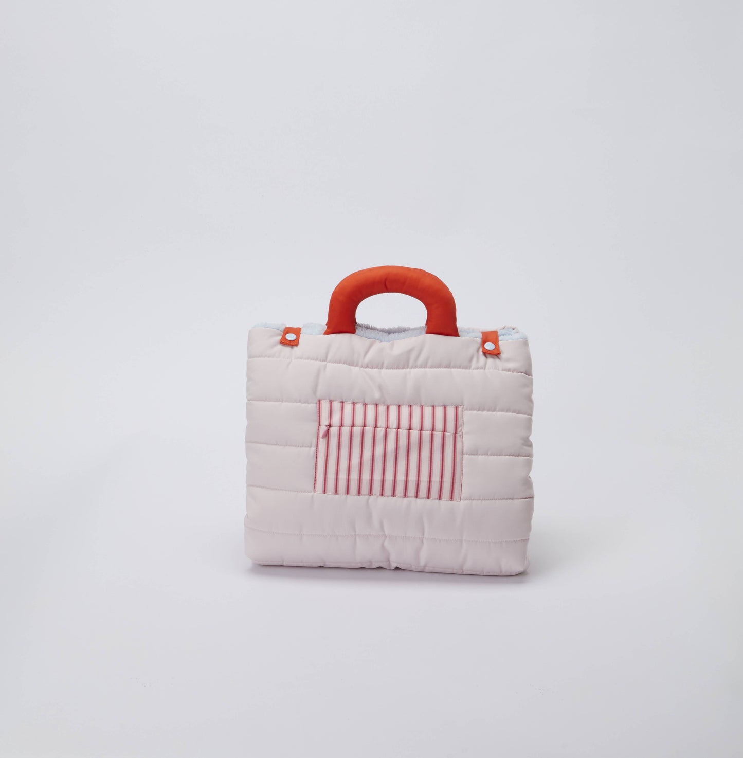 Small quilted dog bag with a red handle and striped pocket on a light gray background
