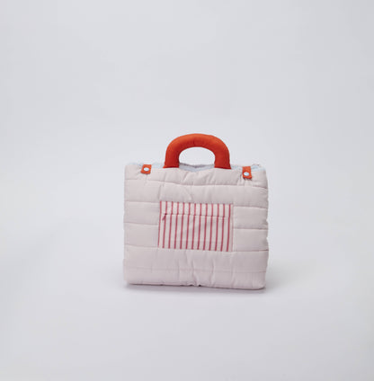 Small quilted dog bag with a red handle and striped pocket on a light gray background