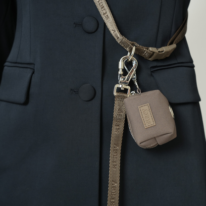 Brown leather pouch with strap attached to a dark coat