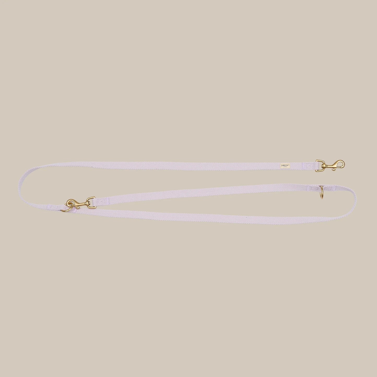 Thin lavender leash with gold hardware on a beige background