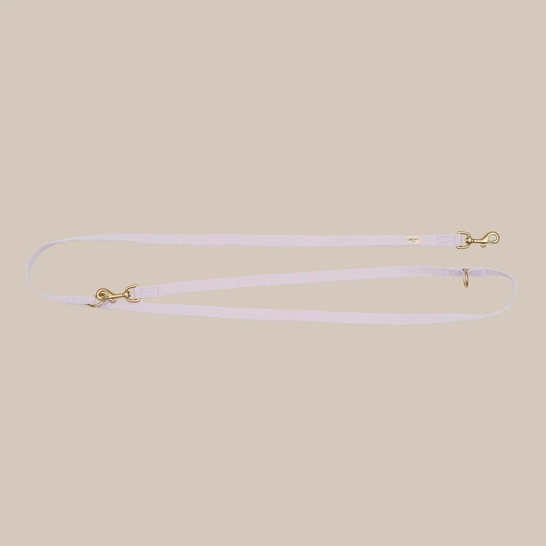 Thin lavender leash with gold hardware on a beige background