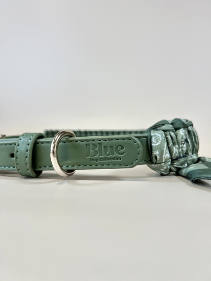 Green dog collar with camouflage pattern and 'Blue' brand name on a light gray background