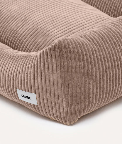 Beige corduroy pet bed with a visible brand label on a white background