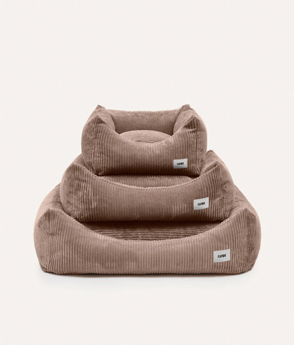 Two brown corduroy pet beds with visible labels on a white background