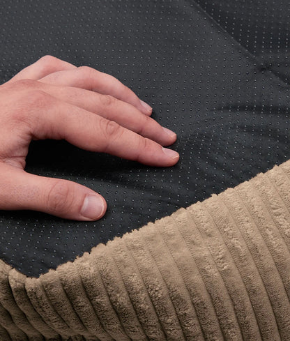 Hand touching a textured black and beige fabric surface