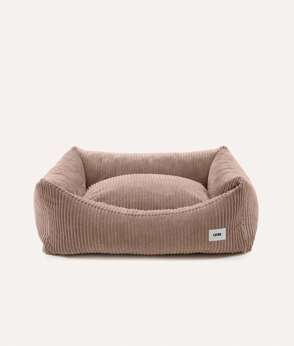 Brown pet bed with a visible brand label on a white background