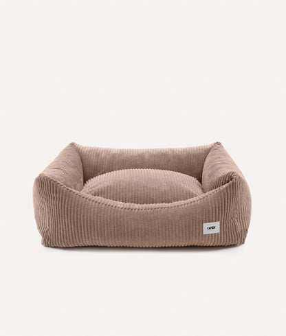 Brown pet bed with a visible brand label on a white background