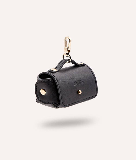 Black sustainable innovative leather dog waste bag with gold accents on a white background