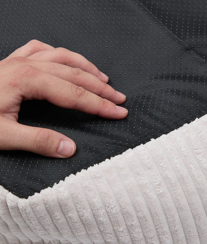 Hand pressing onto a textured black and white mattress surface