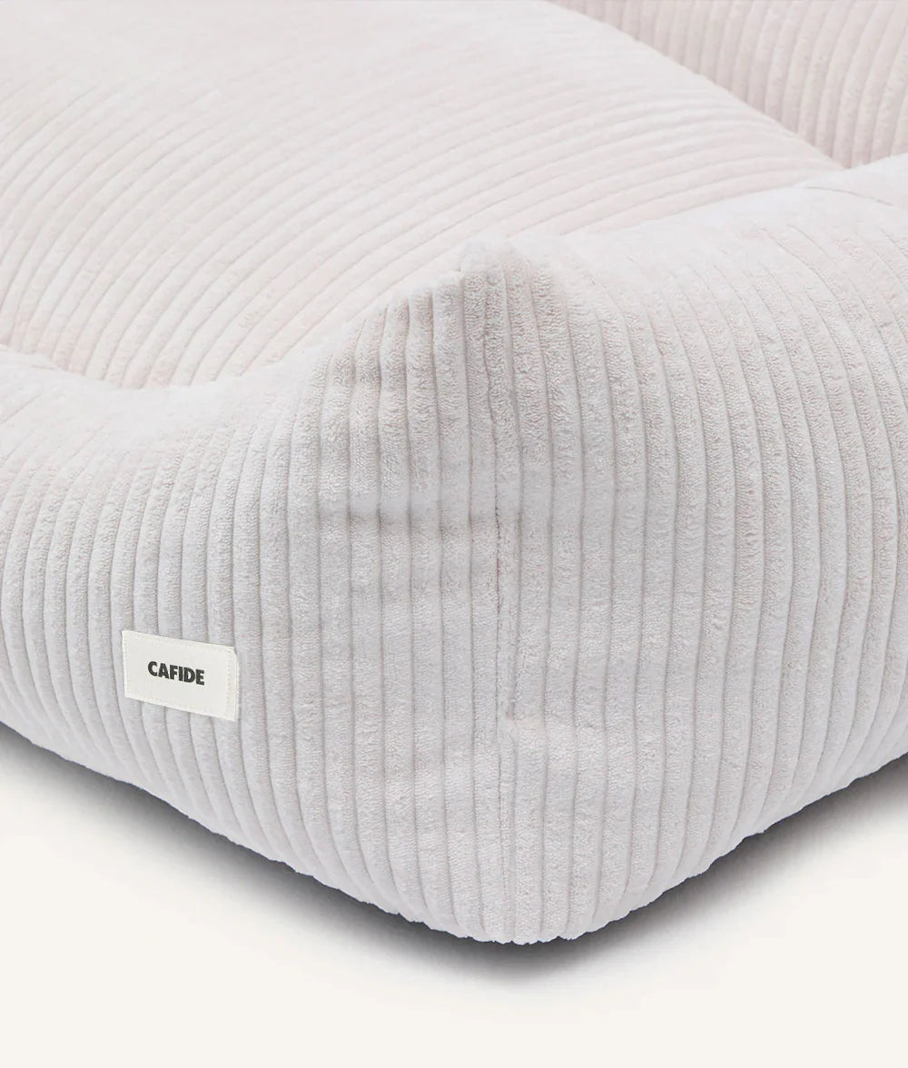 Gray textured cushion with a visible brand label on a light background