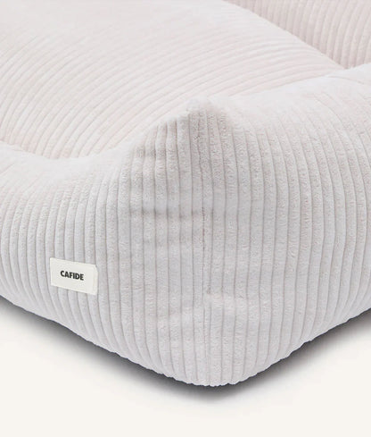 Gray textured cushion with a visible brand label on a light background