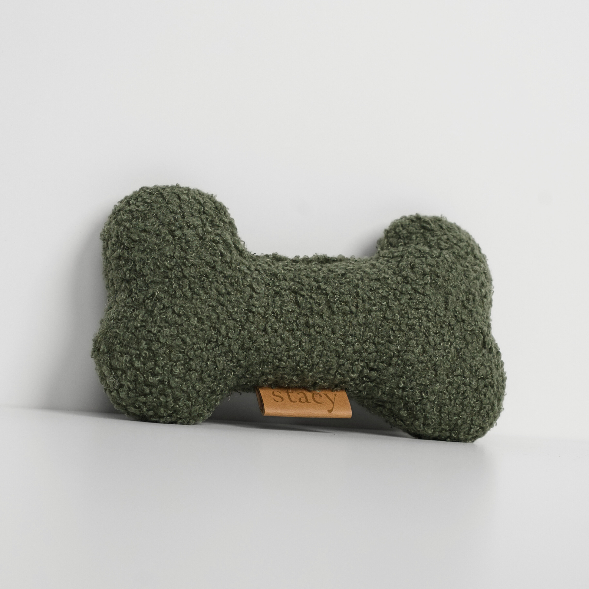 Green textured dog toy with a brand label on a light gray background