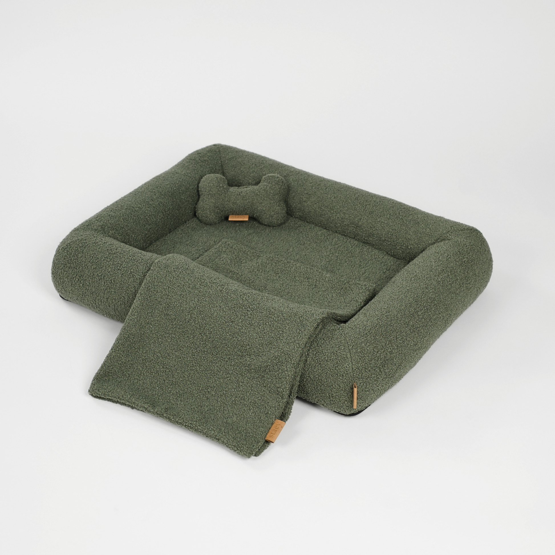 Green pet bed with a bow-shaped pillow on a white background