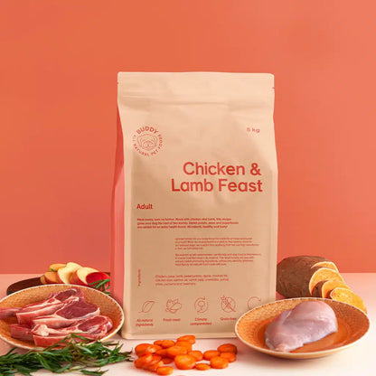 Bag of 'Chicken & Lamb Feast' pet food with ingredients on a peach background