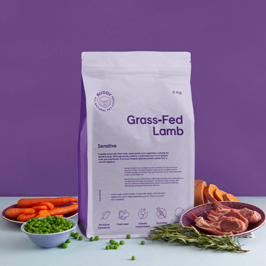 Bag of Buddy Naturals Grass-Fed Lamb dog food with ingredients on a purple background
