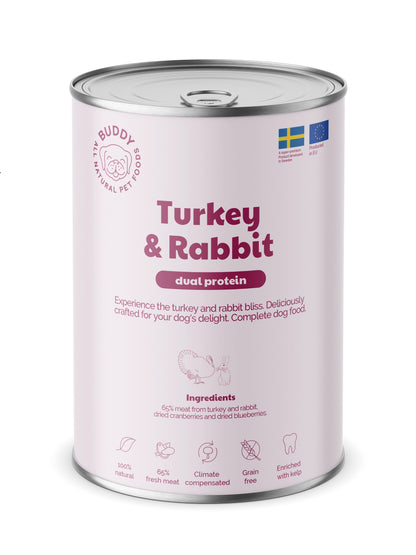 A can of Buddy Turkey & Rabbit dual protein wet dog food, featuring a light pink label with purple text and graphics on a white background.