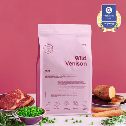 Bag of Buddy Food Wild Venison dog food with ingredients on a pink background