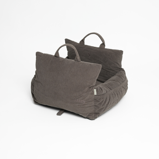 Gray pet bed with two pillows on a white background