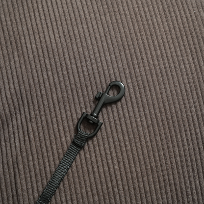 Black strap with a clip on a brown textured background