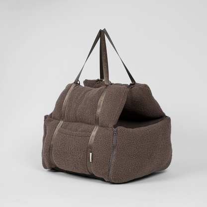 Brown textured pet carrier with a roof on a light gray background