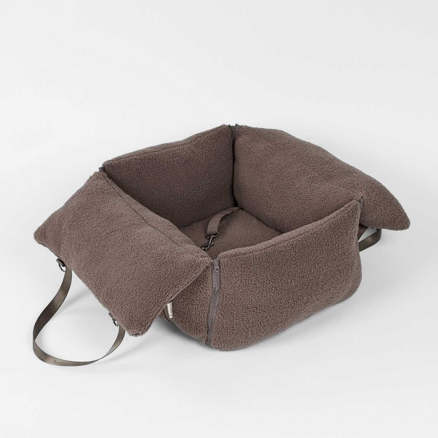 Brown fabric dog seat with straps on a white background