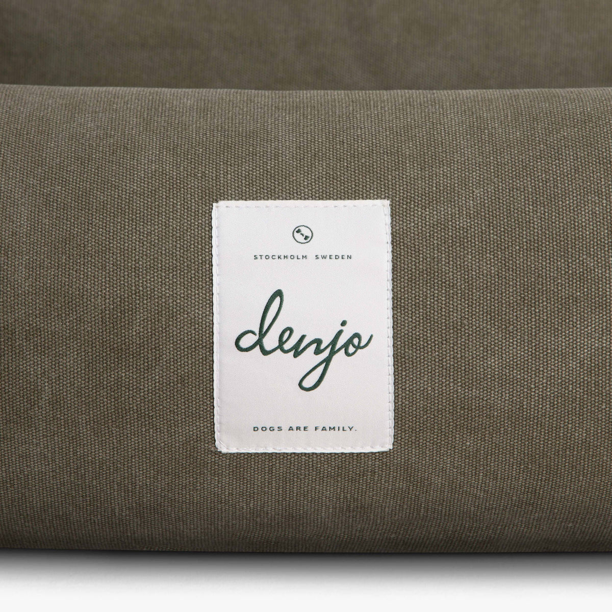 Green cushion with a white label featuring the brand 'denjo' on a matching green background.