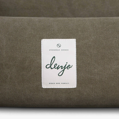 Green cushion with a white label featuring the brand 'denjo' on a matching green background.