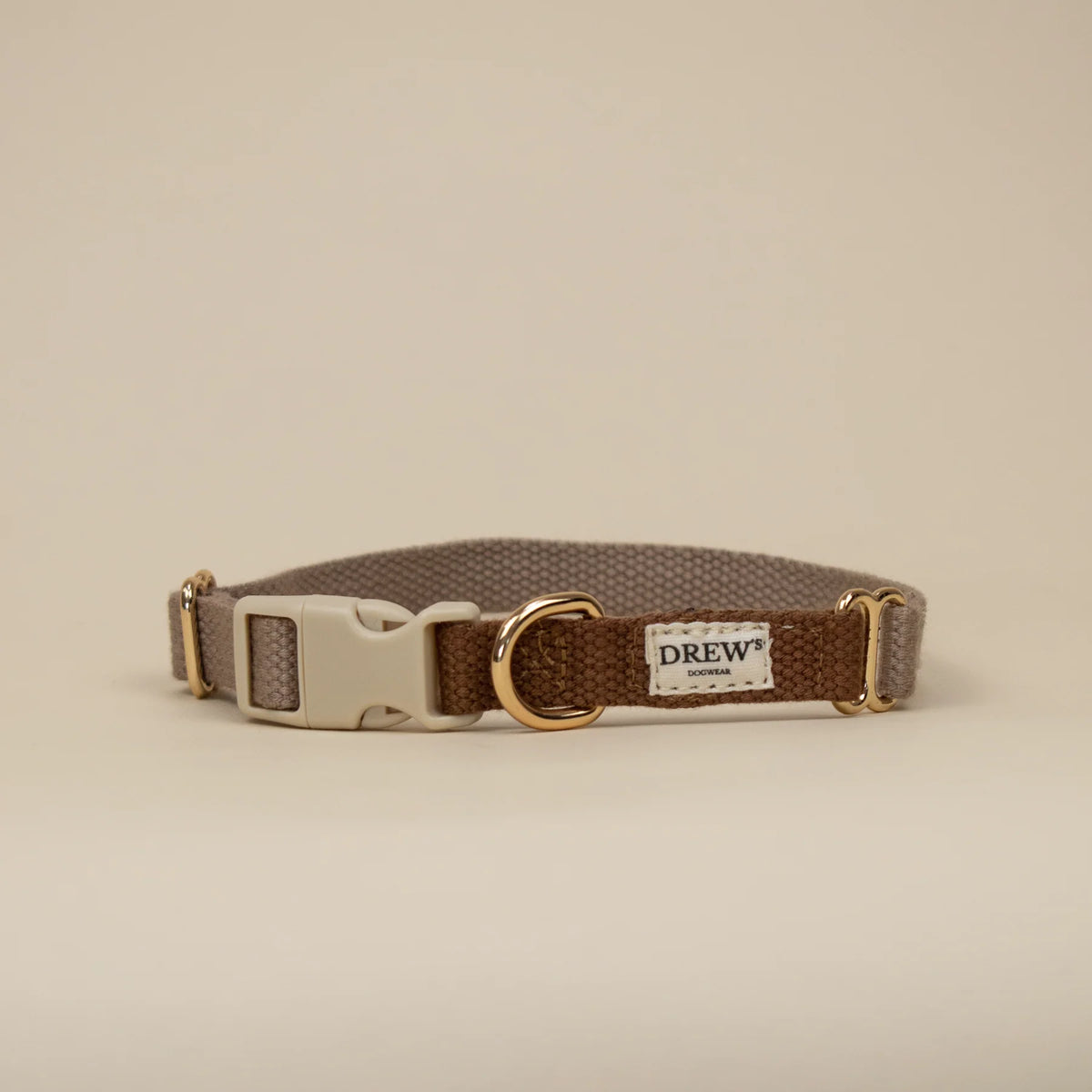 Brown dog collar with gold buckle on a beige background