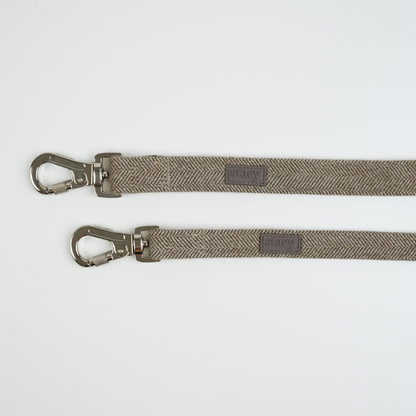 Two gray dog leashes with metal clasps on a white background