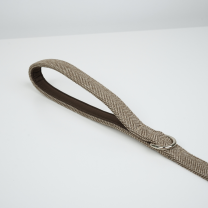 Beige woven belt with a silver buckle on a white background