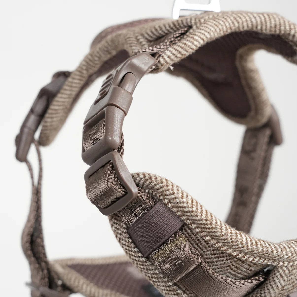 Close-up of a brown dog harness with a white background