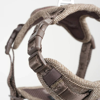 Close-up of a brown dog harness with a white background