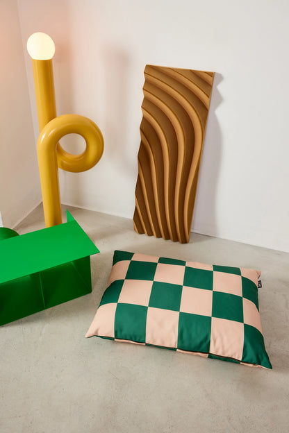 Decorative pillow with green and beige checkered pattern on a neutral background