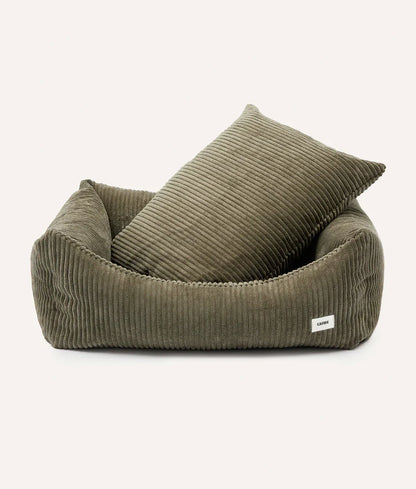 Green corduroy pet bed with a pillow on a white background