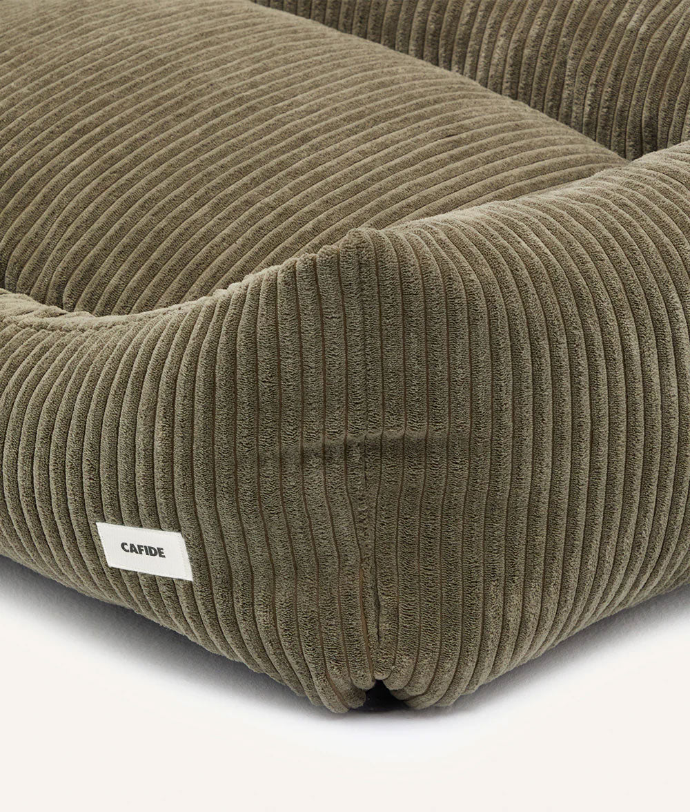 Brown corduroy cushion with a visible brand label on a white background