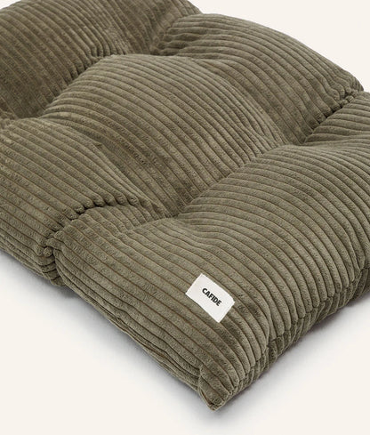 Green corduroy pet bed with a visible brand label on a white background