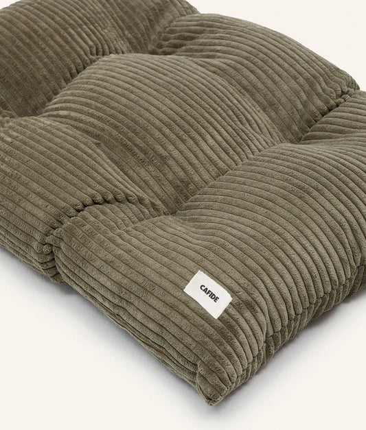 Green corduroy pet bed with a visible brand label on a white background