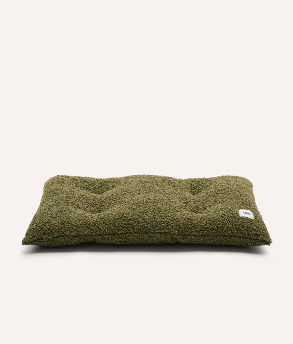 Green pet bed with a brand label on a white background