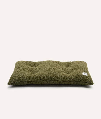 Green pet bed with a brand label on a white background