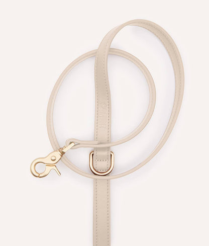 Beige circular handbag with a strap on a white background
