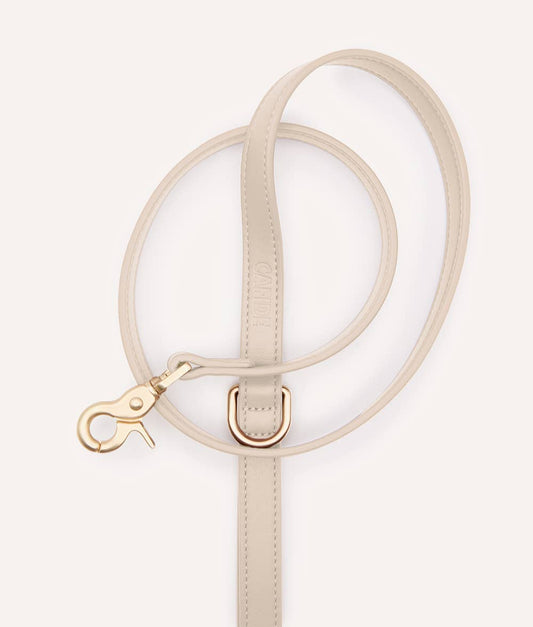 Beige circular handbag with a strap on a white background