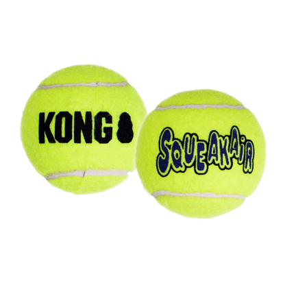 Two yellow KONG SqueakAir tennis balls on a white background