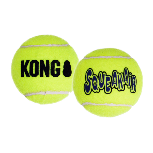 Two yellow KONG SqueakAir tennis balls on a white background