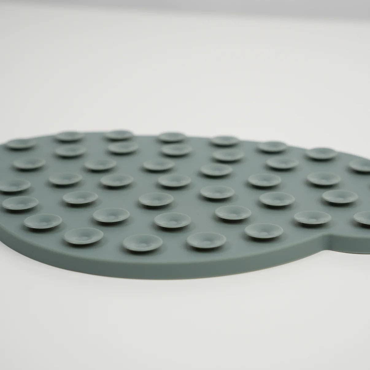 Green silicone mat with textured surface on a white background