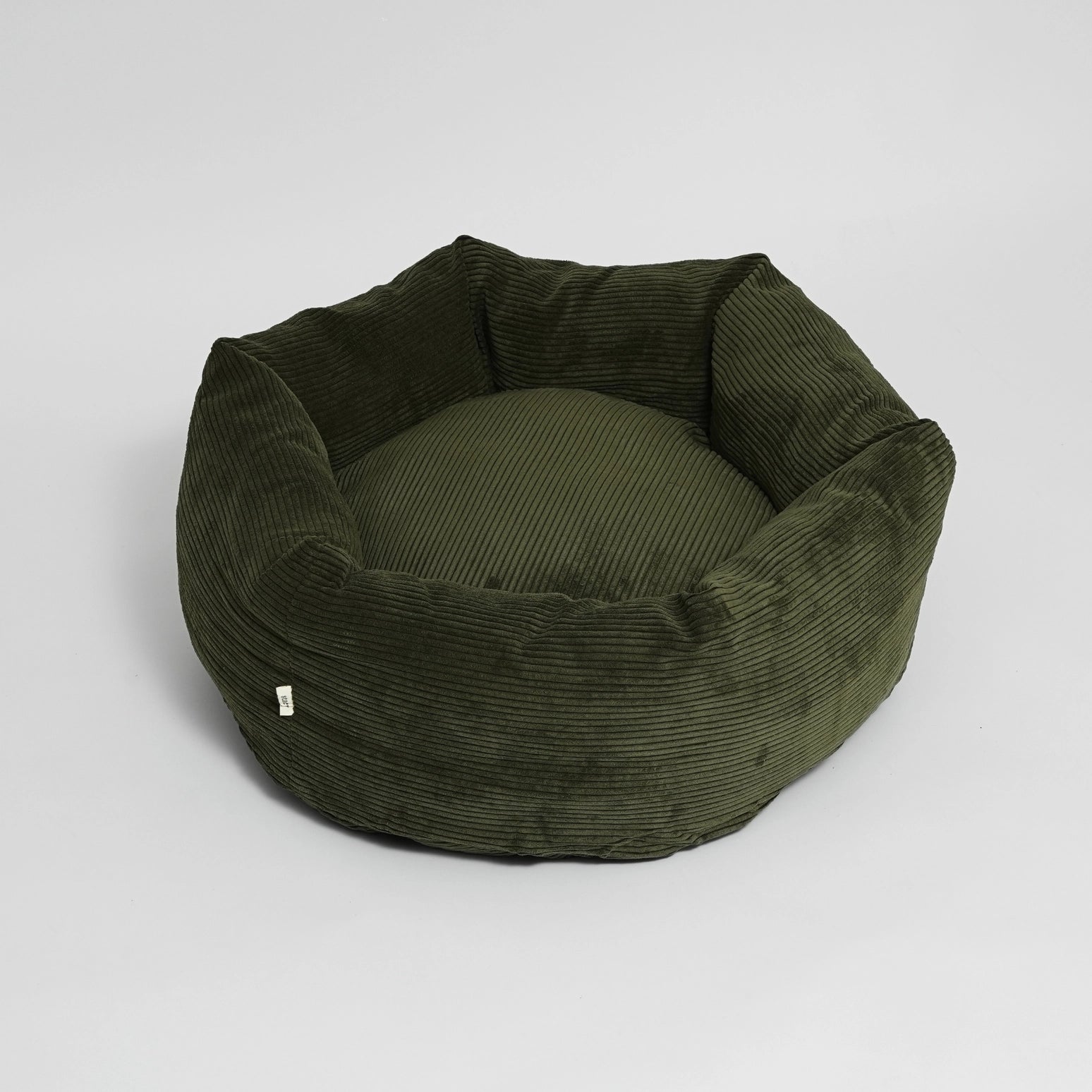 Green corduroy pet bed on a light gray background