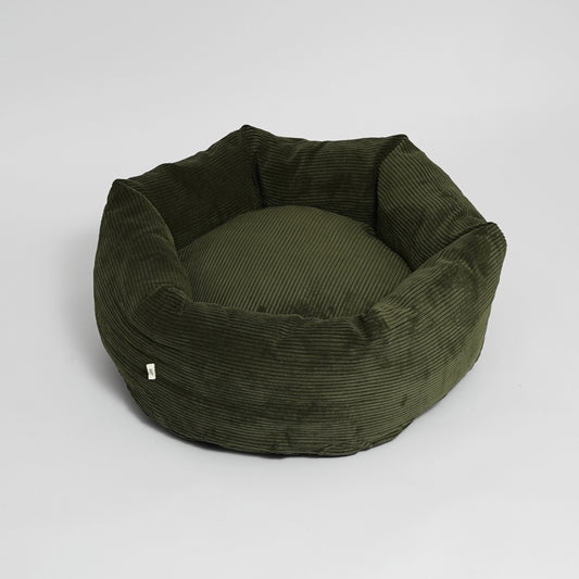 Green corduroy pet bed on a light gray background