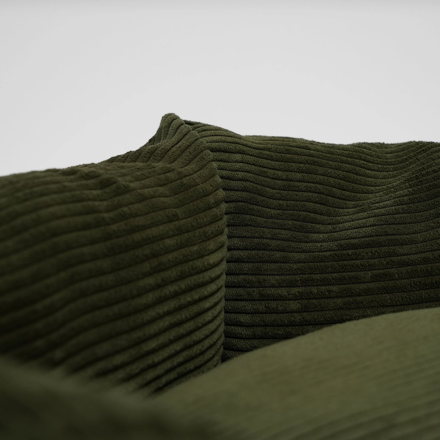 Close-up of green textured fabric with a plain background